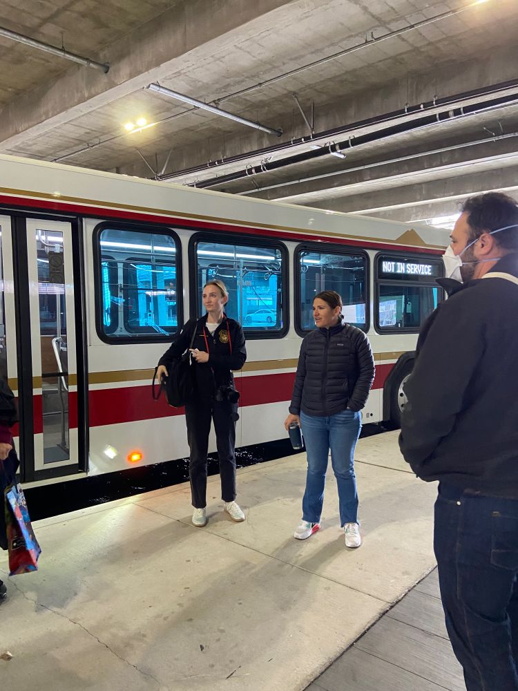 assemblymember rebecca bauer-kahan, one of her staffers, and transbay coalition volunteers stand in front of a county connection bus at walnut creek bart station 