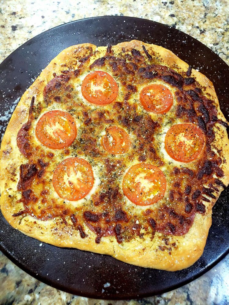 A freshly cooked margherita pizza using homemade dough and whole ingredients