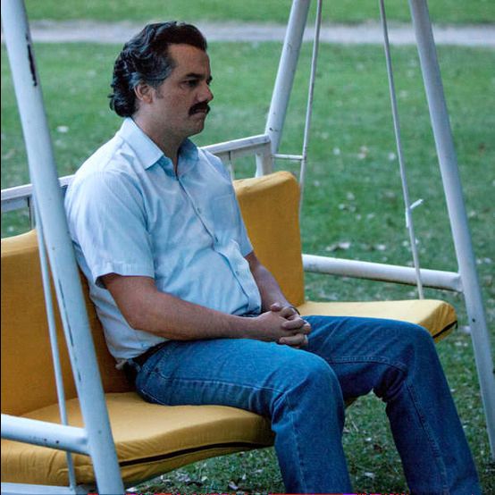 Man sitting on bench swing staring off in sad contemplation 