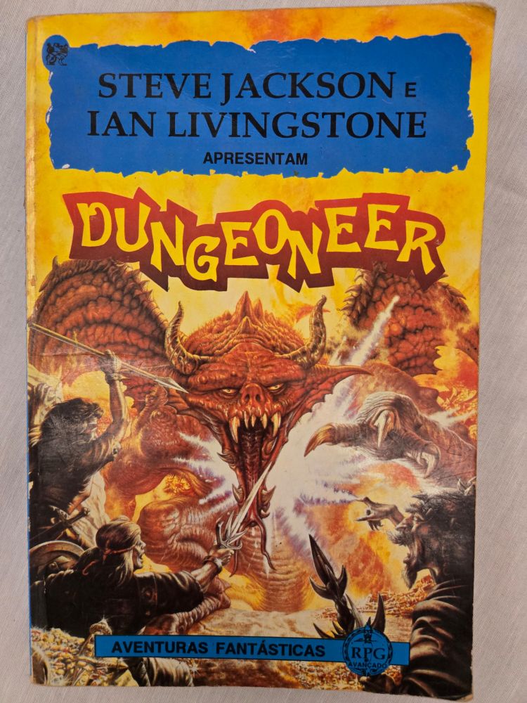 Capa do livro "Dungeoneer" da série Aventuras Fantásticas, apresentado por Steve Jackson e Ian Livingstone. O título está em letras estilizadas amarelas com um fundo vermelho vibrante. A ilustração central mostra um dragão vermelho aterrorizante com asas abertas, dentes afiados e olhos brilhantes, enfrentando três aventureiros armados em um cenário de fogo e destruição. Abaixo, uma faixa azul destaca "RPG Avançado".