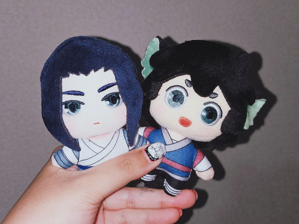 ムゲンとシャオヘイのぬいぐるみを持っている。