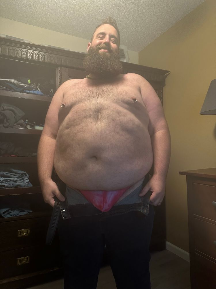 Bear shirtless in a pink thong and open jeans. 