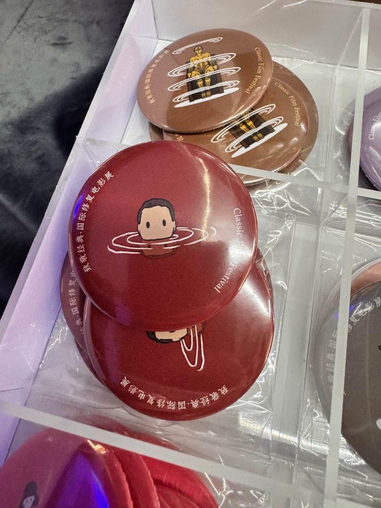 映画『地獄の黙示録』をデザインした缶バッチの写真です。ポスターにも使われている、水面から鼻までを出している男の姿が、デフォルメで描かれています。