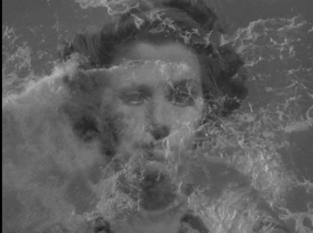 The face of Belle Chrystall superimposed on to the crashing waves beneath the rocks at Foula in The Edge of the World