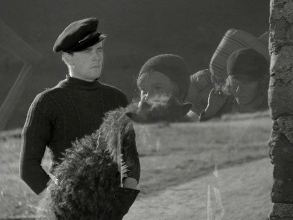 Niall McGinnis as Andrew Gray, surrounded by the ghosts of the islanders in The Edge of the World