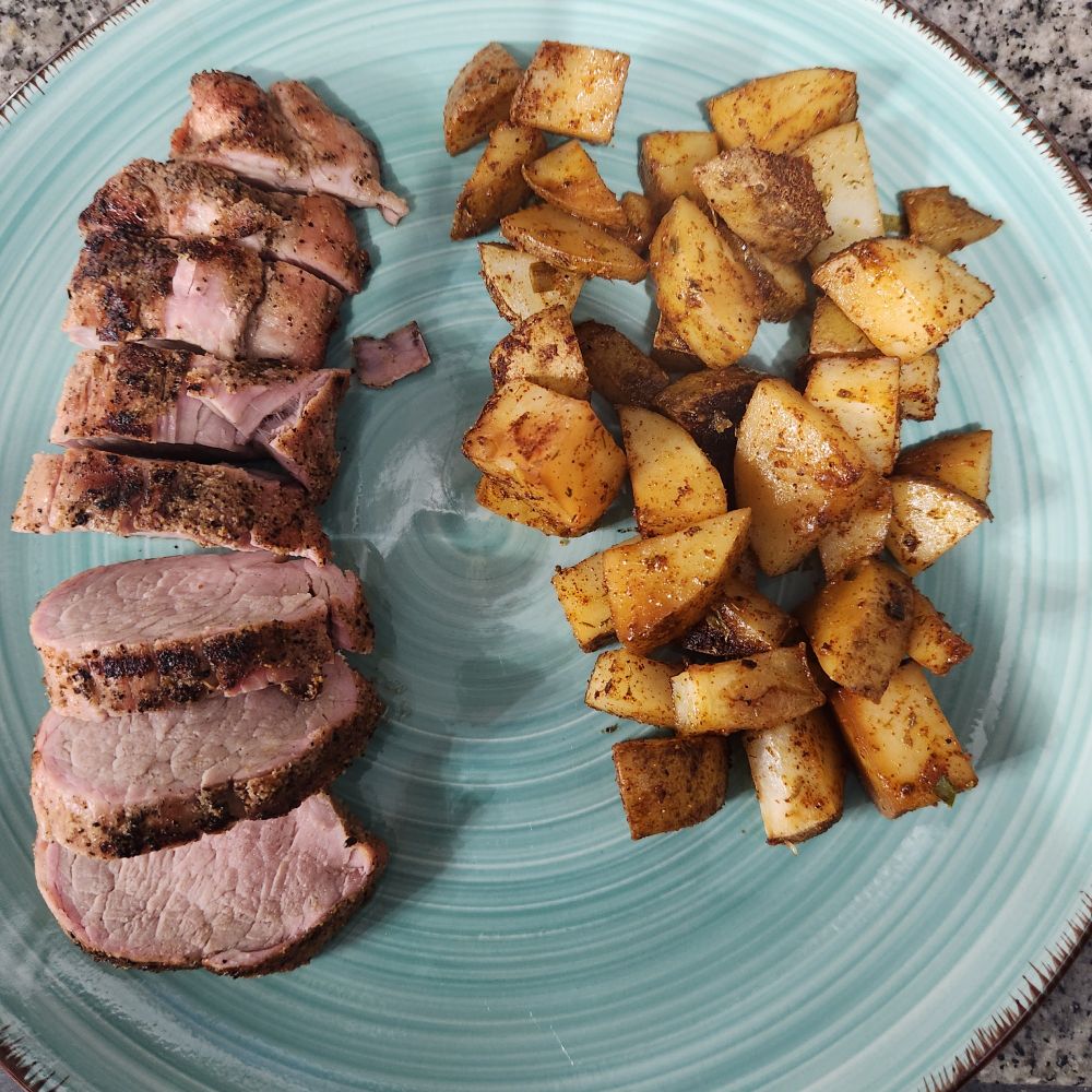 Simple meal of grilled pork tenderloin and baked chive and dill potatoes.