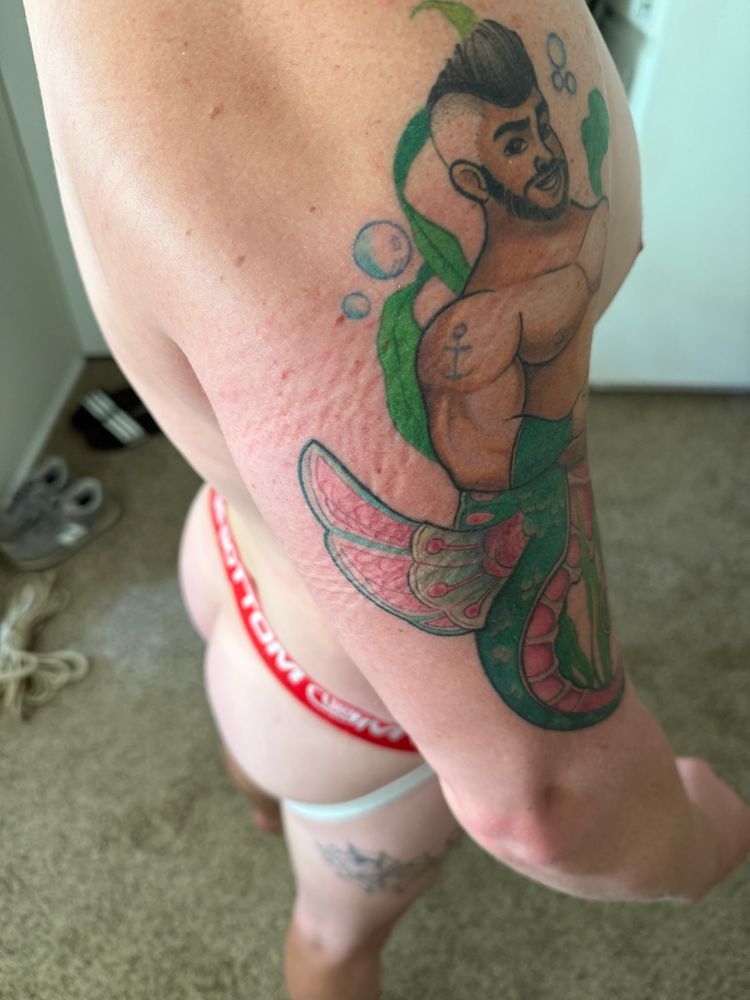 Side view of bicep with rope imprints, ass visible in background 