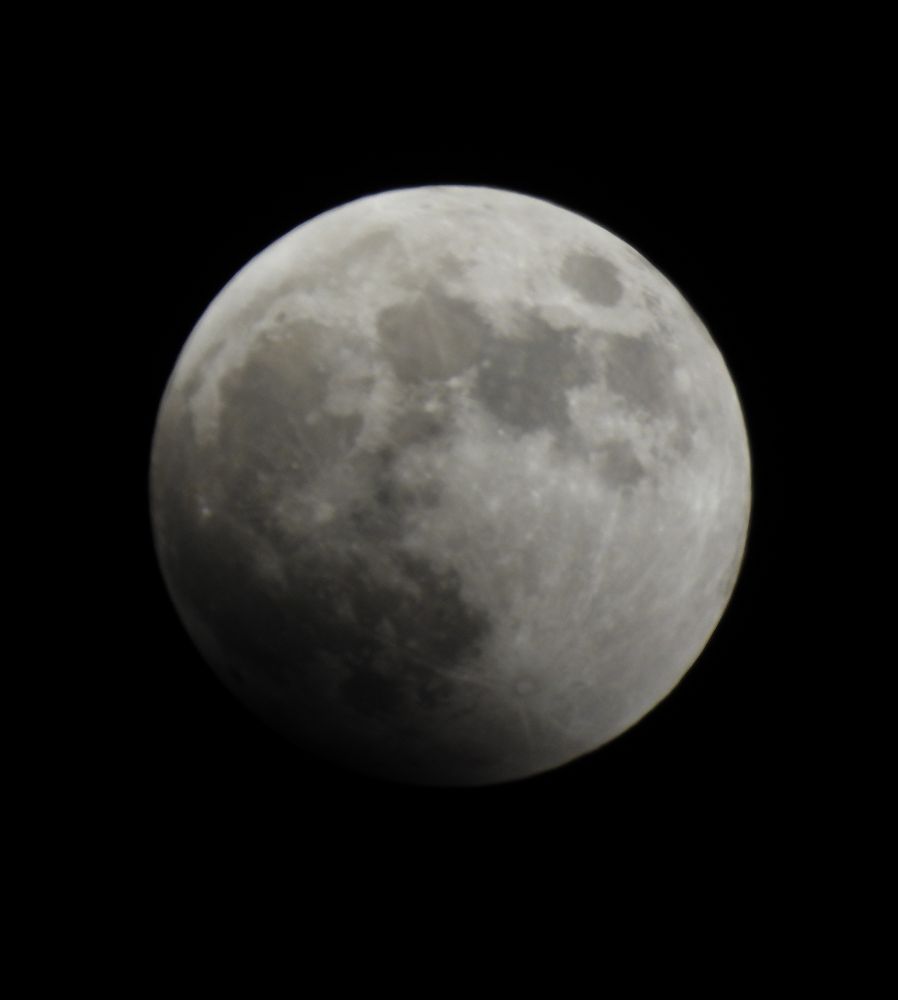 Moon, with earth's shadow beginning to show, at lower left