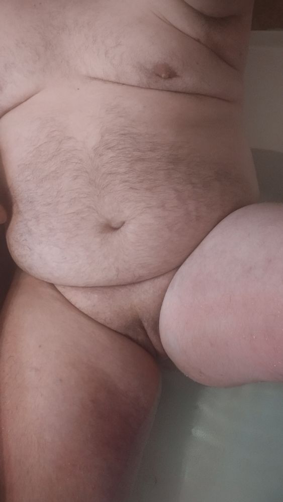 Laying in the bathtub with legs slightly open, showing off their chubby cunt