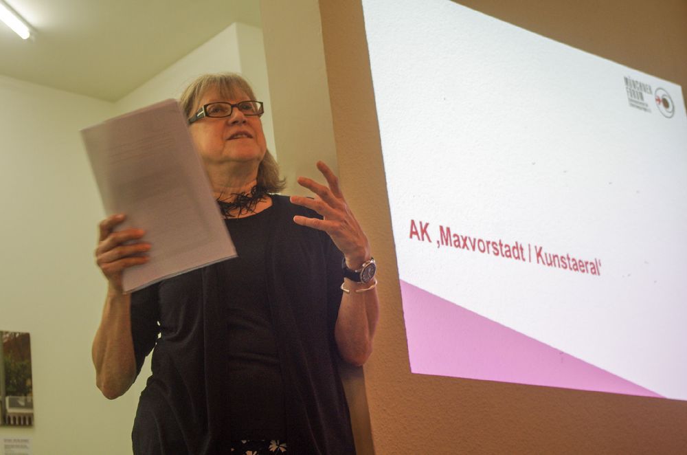Eine Frau hält einen Vortrag vor einer Präsentation.