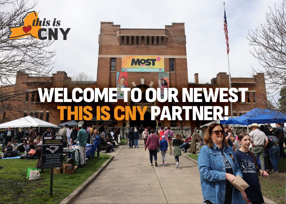 a picture of a brick building, a former armory that is now a science and technology museum. people are on the grounds walking and under tents during an event. text over image says Welcome to our newest This is CNY partner!