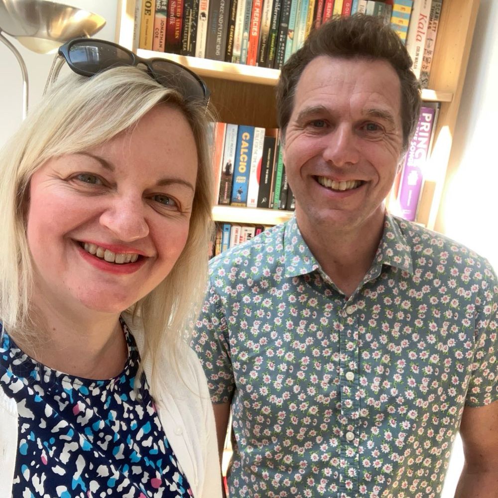 Jo and Christopher in front of a book case