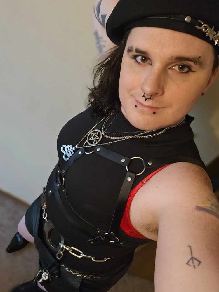 Sabryna wearing a lot of chains, necklaces, and a harness. She's also wearing a beret. All in all she looks like an edgy femme fatale from the 90s