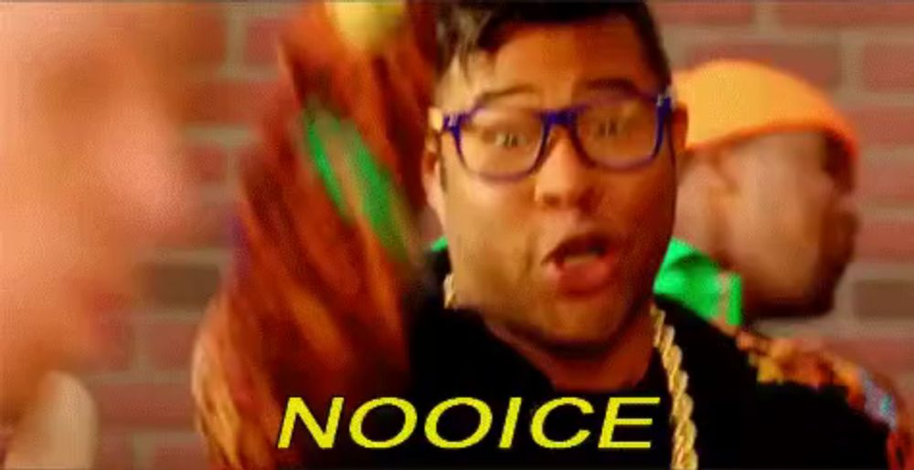 a man wearing glasses and a necklace says " nooice "