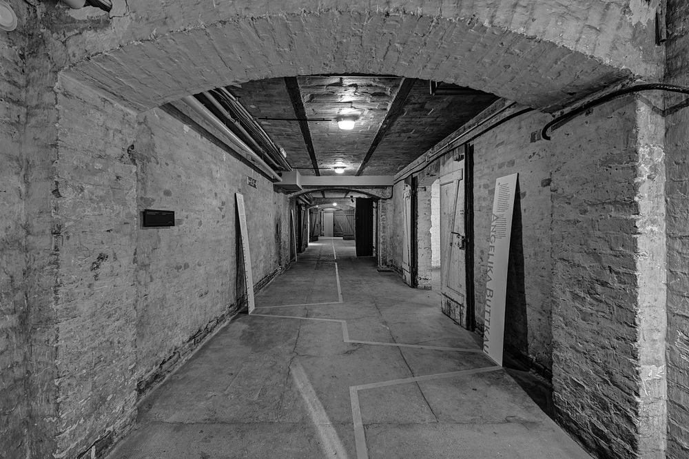 A.Savin: Räume des ehemaligen SA-Gefängnisses Papestraße (Werner-Voß-Damm), Berlin-Tempelhof, 2015. Schwarz weiß Foto zeigt unterirdischen Gang,  von dem Türen abgehen. Nachweis von wiki commons folgt 