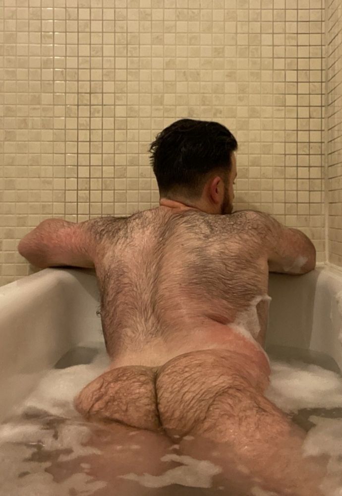 Rossy is facing away from the camera in a bathtub.