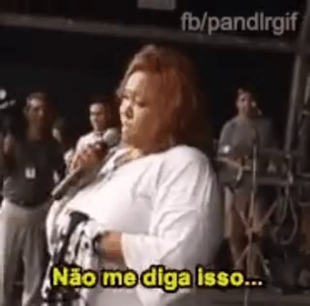 a woman is singing into a microphone and saying `` não me diga isso ... ''