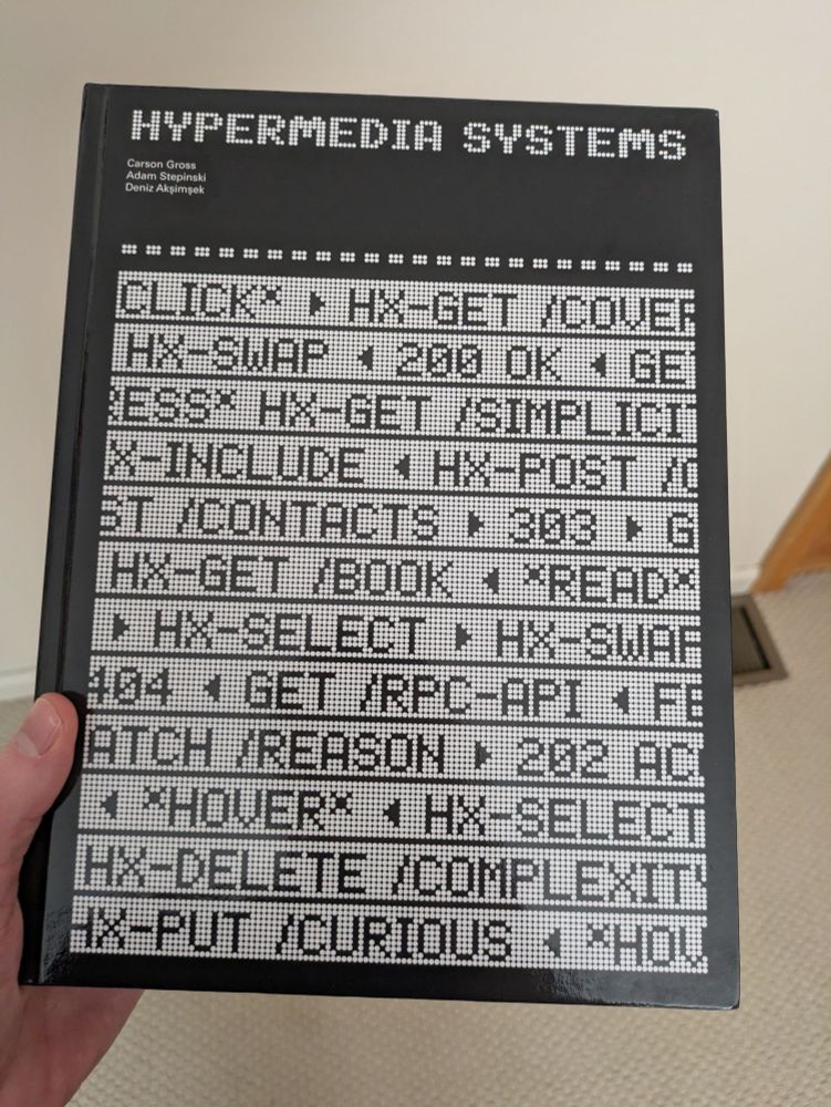 Me holding the Hypermedia Systems hardcover