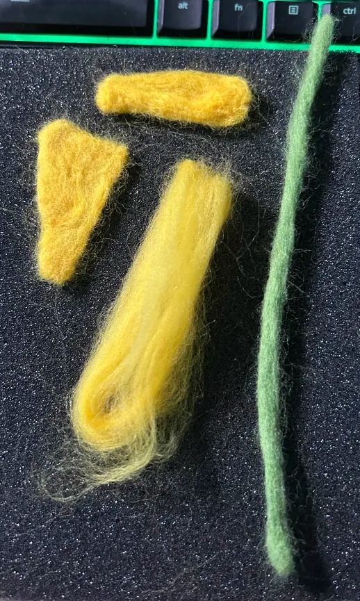 Yellow and green Merino Wool for spinning & felting, being felted into the shape of flower petals and a stem. Wool from Eugene Textile Center, colors are Lemon and Kiwi. www.EugeneTextileCenter.com