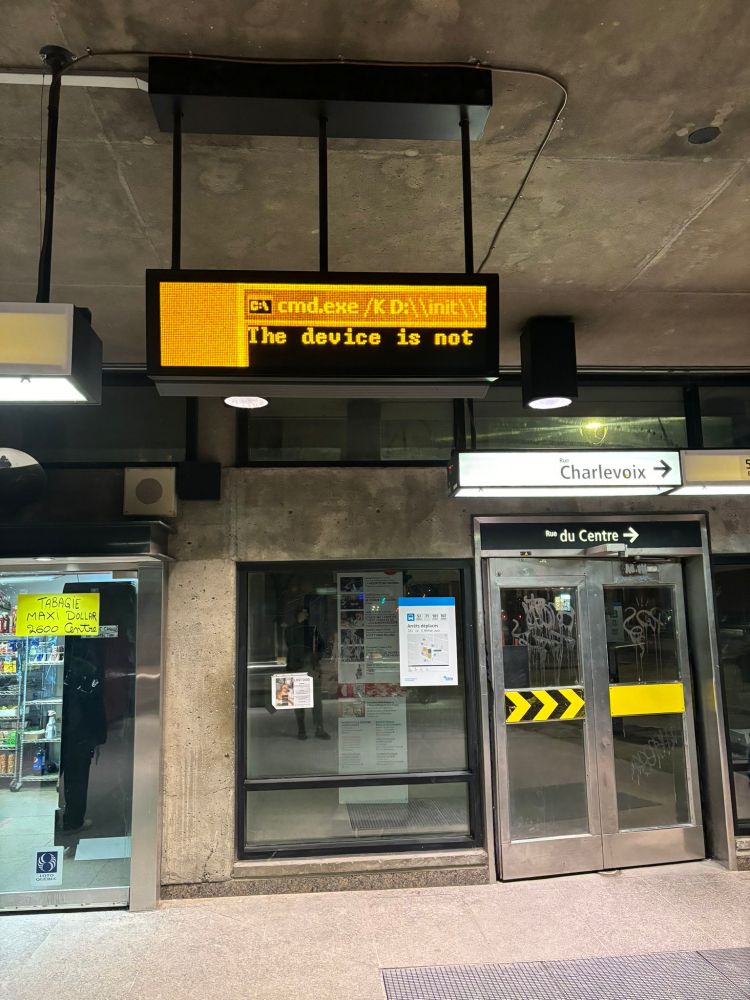 A Montreal metro alert screen which has glitched out, showing Windows command prompt with a yellow-tinted LCD screen.