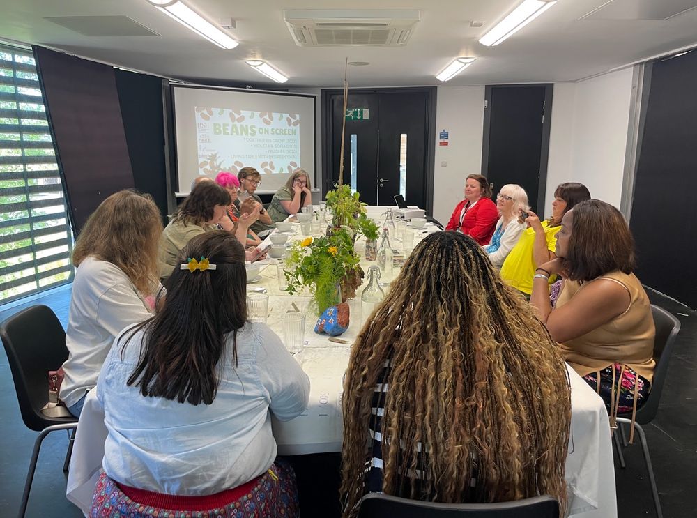 Attendees taking part in a group discussion around the table.
