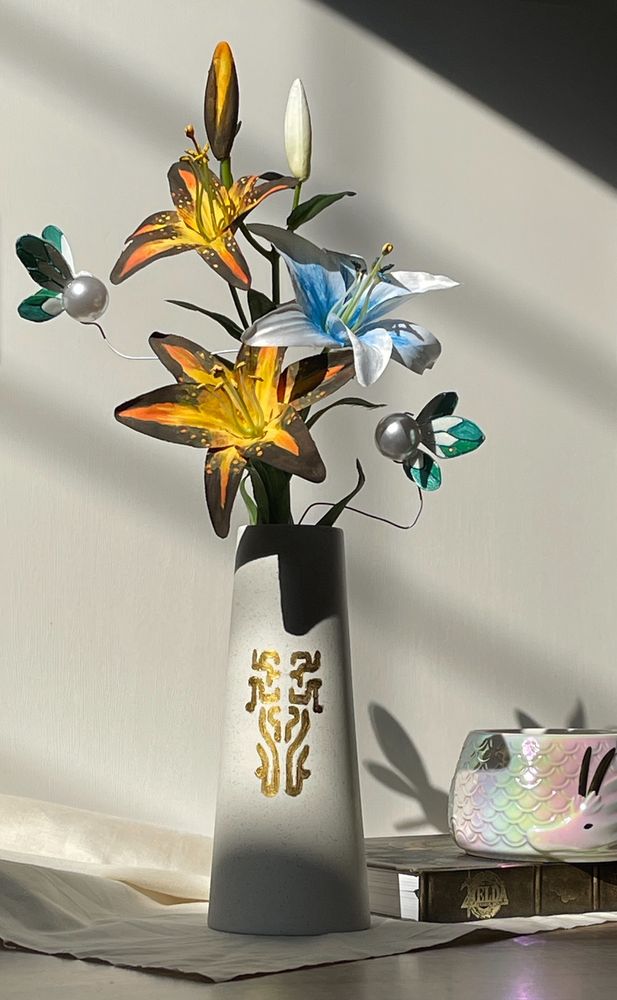 Zelda Sundelion flowers (yellow and black) with Zelda Silent Princess flowers (white and blue flowers) and Zelda fairies (white pearlescent with white and green wings) in a Zonai patterned vase and sitting in soft light 