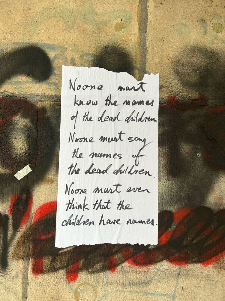 A sign that reads 
No one must know the names of dead children 
No one must say the names of the dead children 
No one must ever think that the dead children have names 