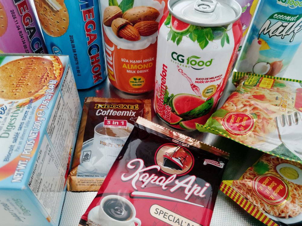 買ってきた食品を並べた写真。
インドネシアのコーヒー、ベトナムのジュース4種類（スイカ、パッションフルーツ、ココナッツミルク、アーモンドミルク）、BRITANIAシュガーフリーダイジェスティブビスケット、スペインのビスケット、ネパールのインスタントラーメン