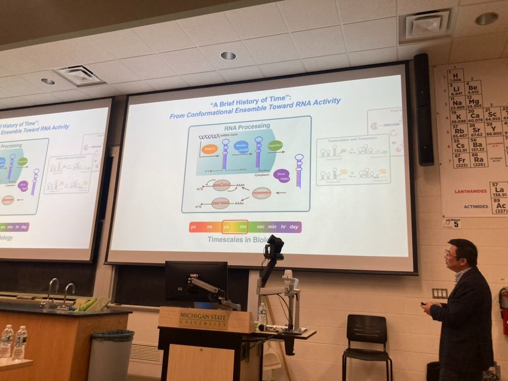 Qi Zhang, a Professor at UNC Chapel Hill, presents a slide titled "A brief history of time, from conformational ensemble toward RNA activity". On the slide are images of RNA processing including microRNA and dicer enzymes. At the bottom of the slide is a schematic of different timescales ranging from picoseconds to days, representing timescales of biology. Microseconds to milliseconds are boxed in red indicating the timescale of RNA processing in biology.