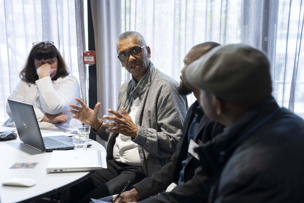 Participants take part in roundtable discussions during the dialogue, seated in small groups and engaging with the session materials.