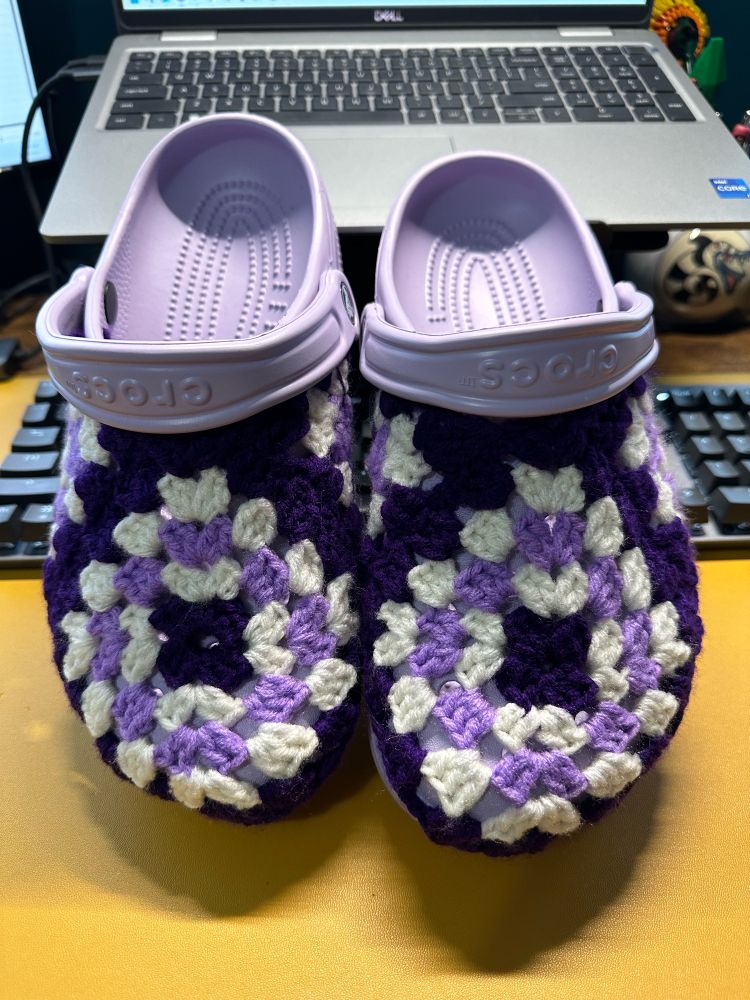 Purple crocs with granny square covers in shades of purple and white 