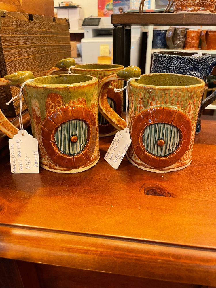 Hand built mugs featuring a green hobbit door design 