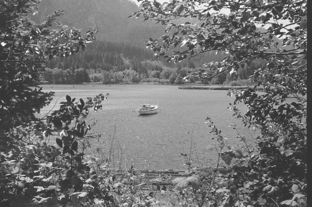 A black and white photo of a boat on a lake