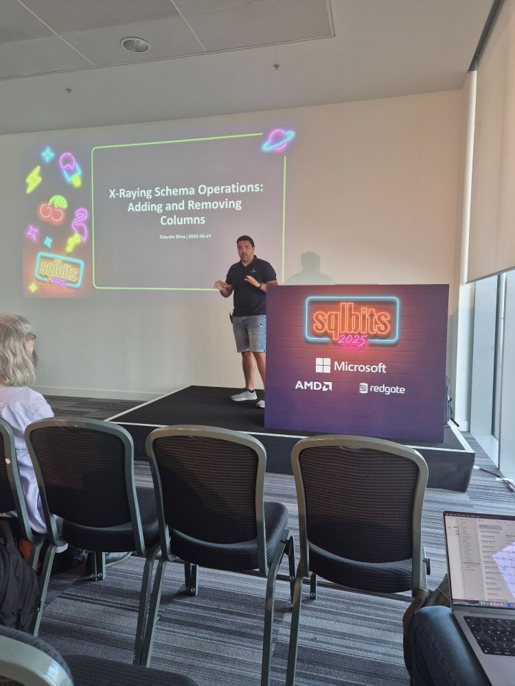 A presenter on stage in front of their slide with the title of the talk on the slide