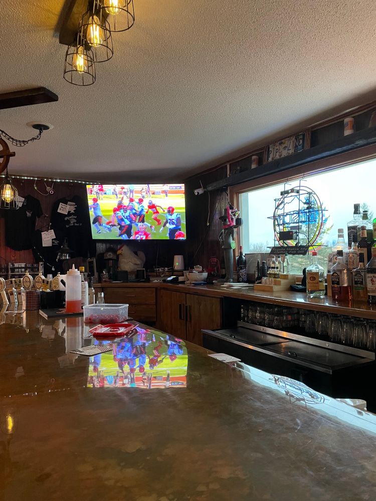 Football game on corner tv at dive bar.