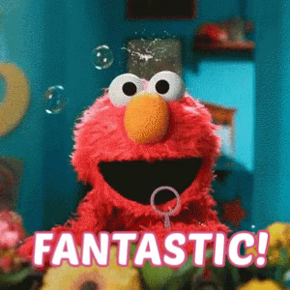 elmo from sesame street is blowing soap bubbles and saying fantastic .