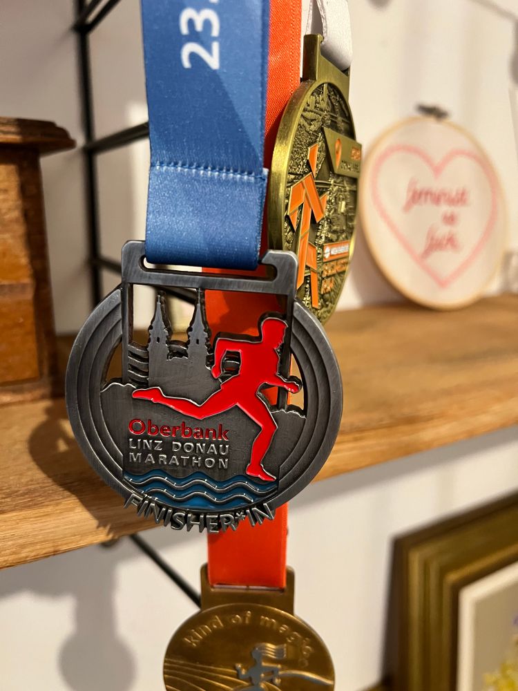 Finisher*in-Medaille von einem 5K-Lauf in Linz. 