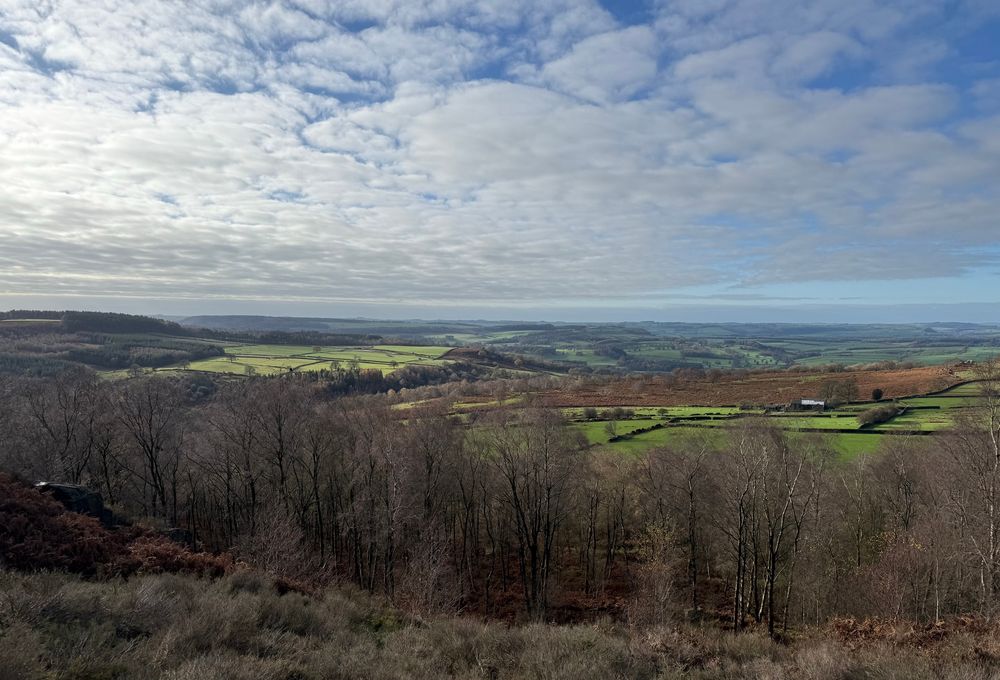A view of the rolling countryside, green fields, blue sky.