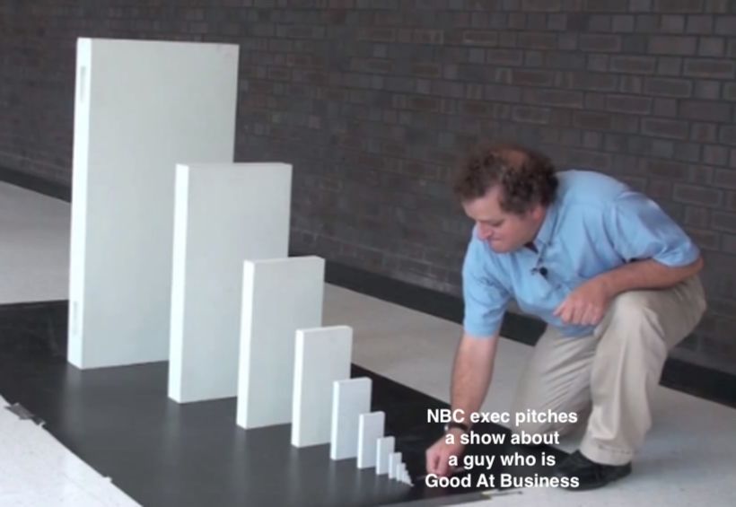meme of a small domino toppling progressively larger dominoes. the tiniest domino is labeled "NBC exec pitches a show about A Guy Who Is Good At Business"
