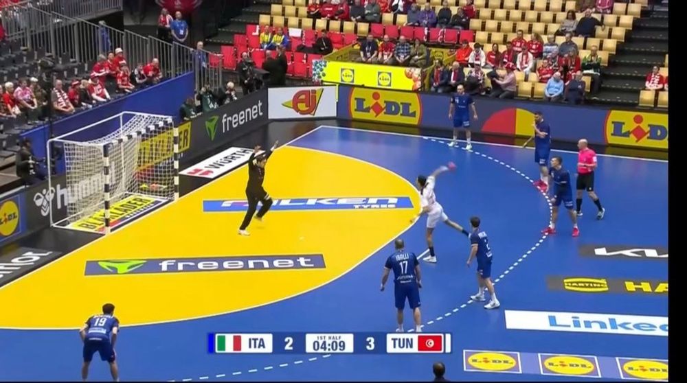 Italy vs. Tunisia in the World Handball championships. Tunisia is shooting a penalty which means the shooter and goalie are standing about 10 feet apart making weird body shapes at each other.