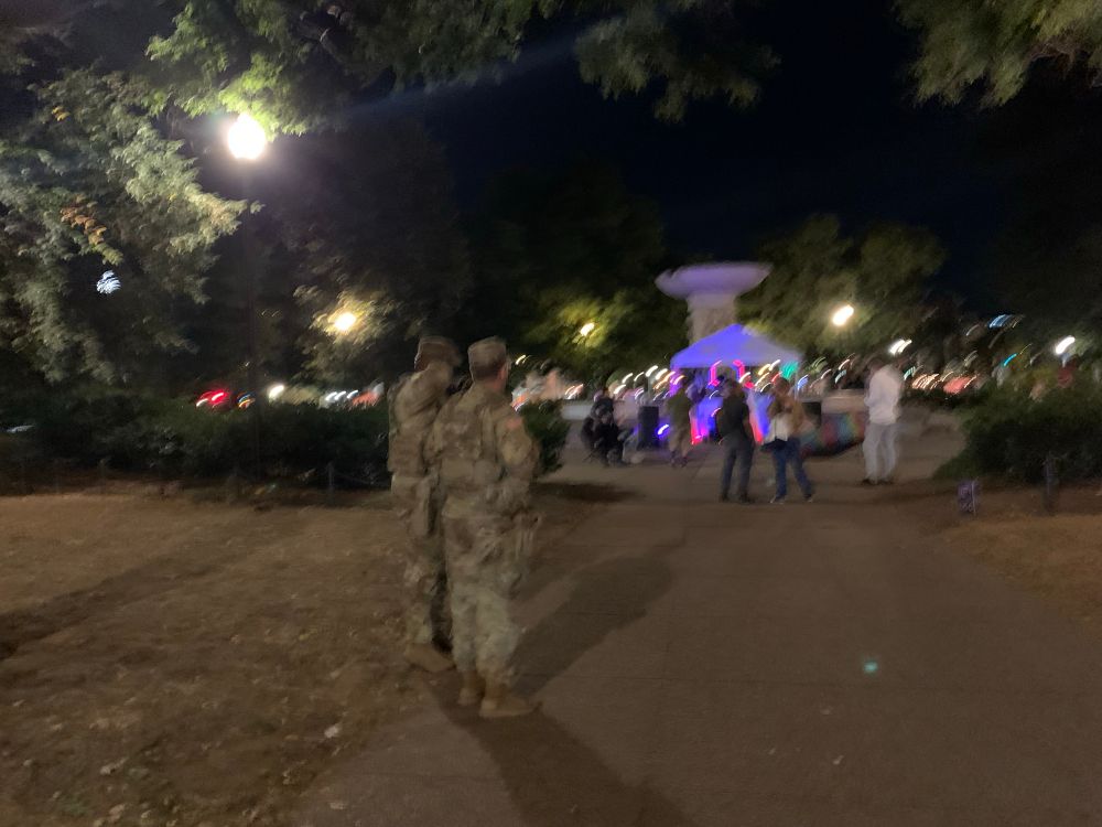 A sadly blurry photo of two members of the National Guard watching the dance party at Dupont Circle. 