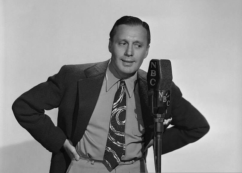 Jack Benny looking at an NBC microphone