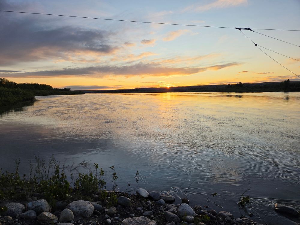 Sun almost gone on the far shore of the river with deepening shadows

