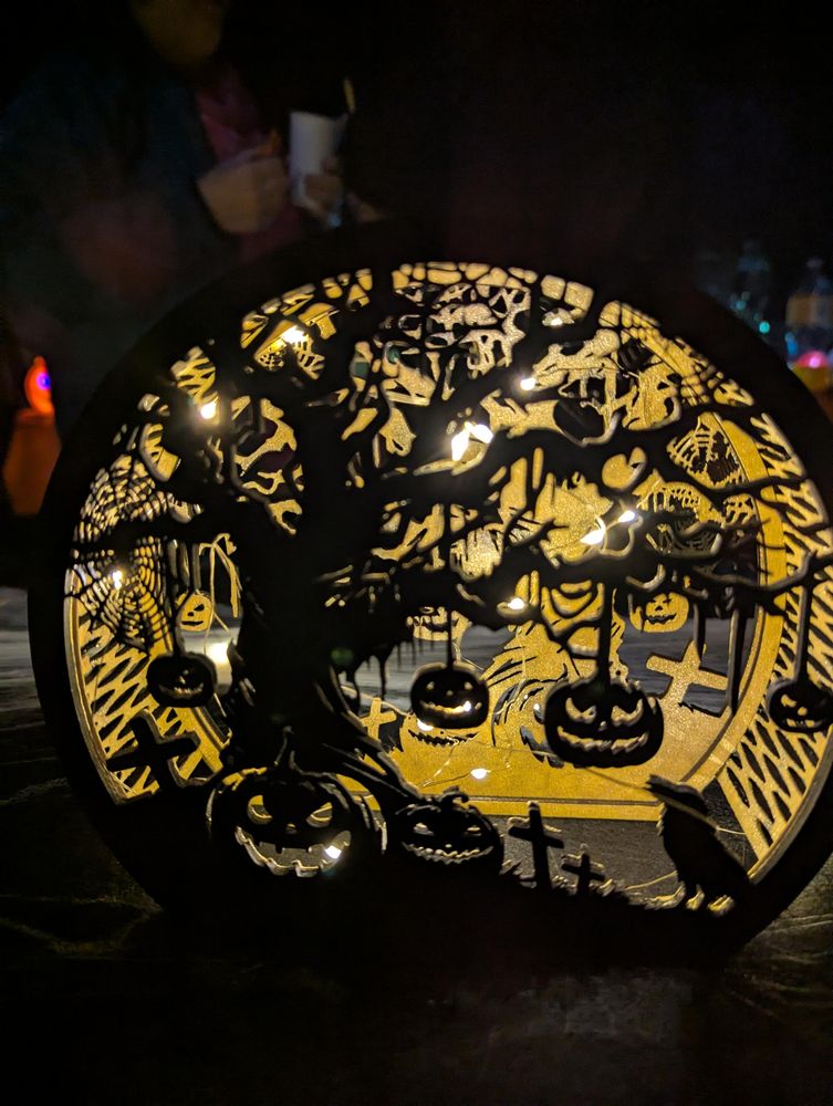 Laser cut lamp with string lights, depicting a spooky tree with pumpkins and crows.