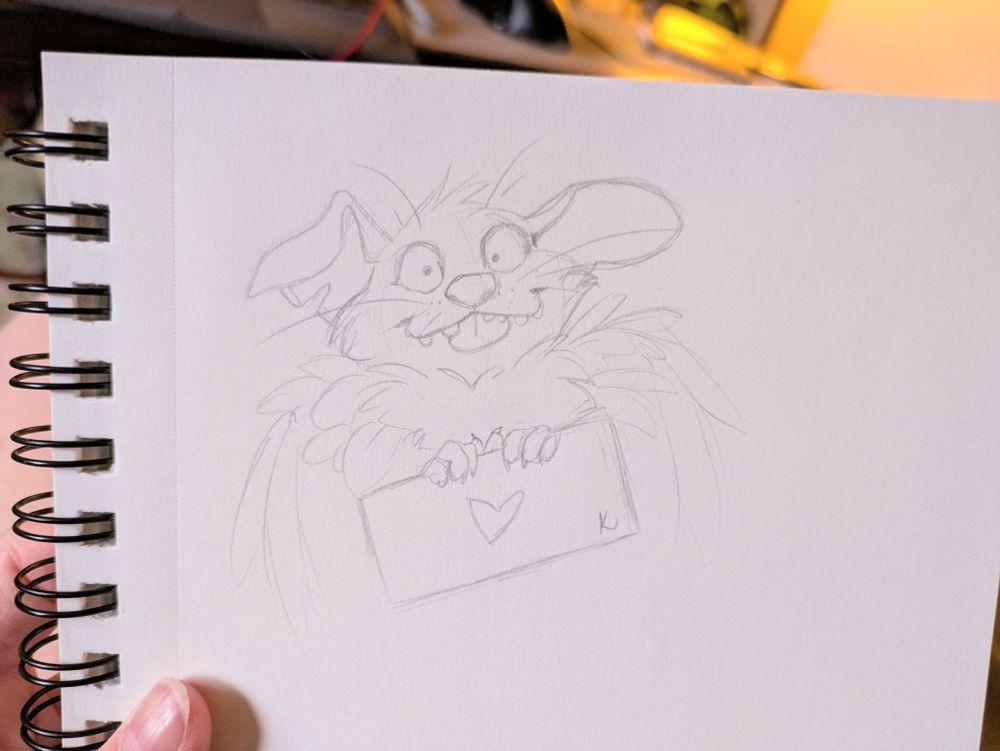 A sketchbook sketch of a feathery large eared creature blepping their tongue and holding a sign with a heart on it 