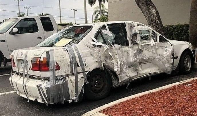 A smashed car with duct tape. Junky car.