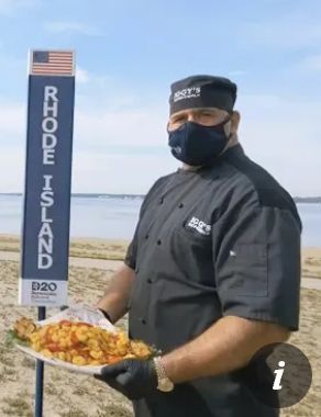 Rhode Island Calamari chef from the 2020 DNC,dressed all in black with a face mask, like a large New England ninja.... holding a calamari platter and wearing a black bandanna reading "Iggy's"