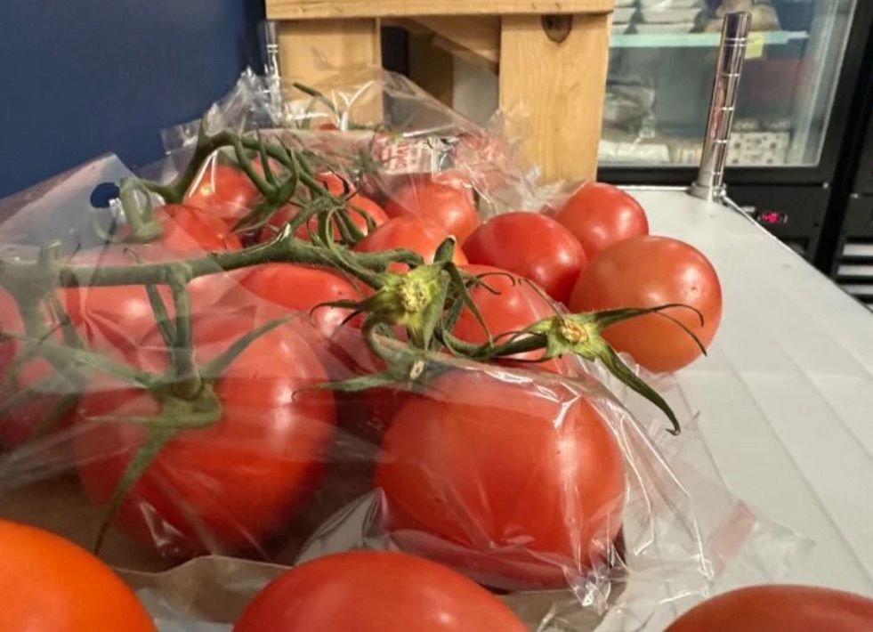 A bunch of tomatoes on a shelf 