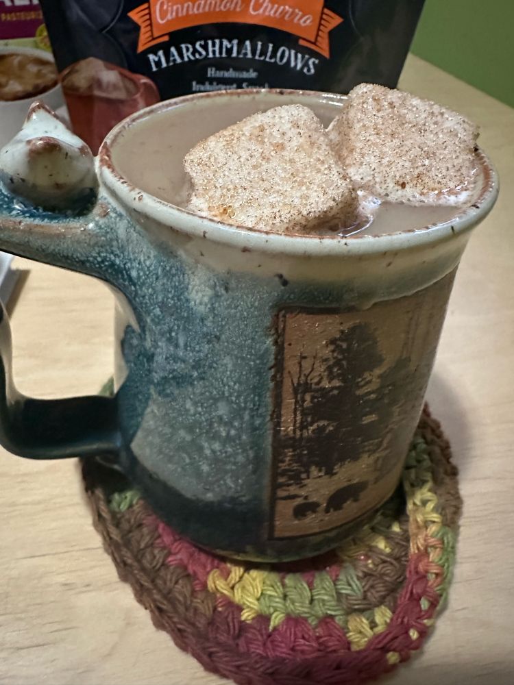 Marshmallow churros in a mug with coffee. 