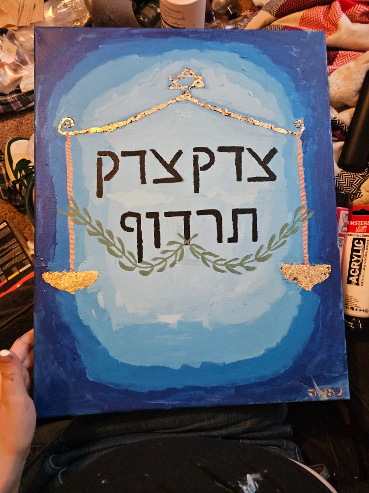 Scales of justice with olive branches and the words "צדק צדק תרדוף" on a blue gradient. Acrylic and foil on canvas. 